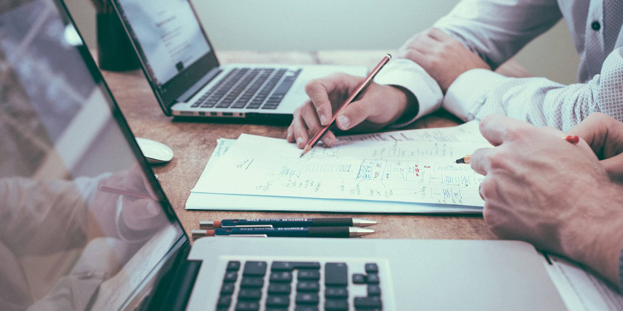 Associés et dirigeants travaillant ensemble sur des documents de gouvernance, symbolisant la formalisation des accords de gouvernance et l’organisation des pouvoirs en société