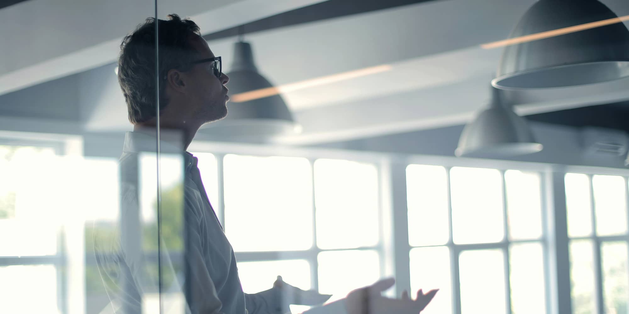 Dirigeant en costume regardant la ville depuis un bureau