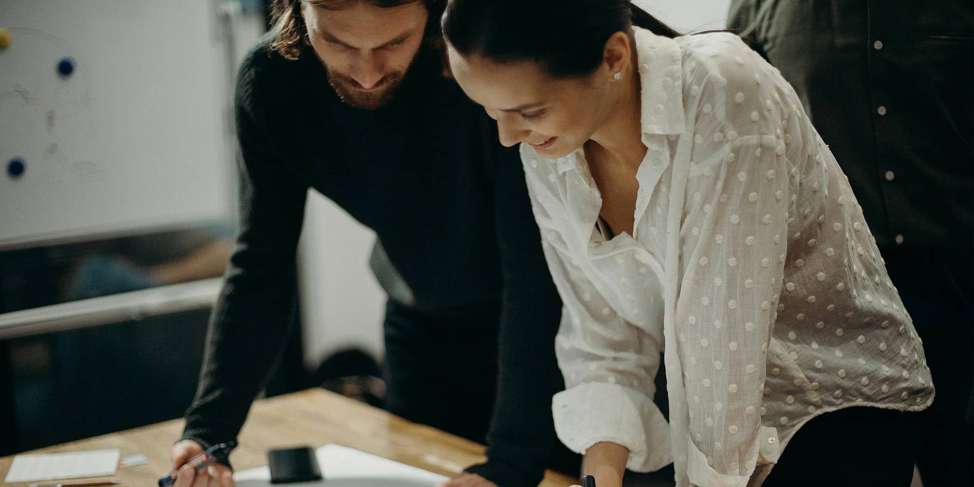 Collaboration entre deux professionnels travaillant ensemble sur un projet commun, symbolisant un consortium