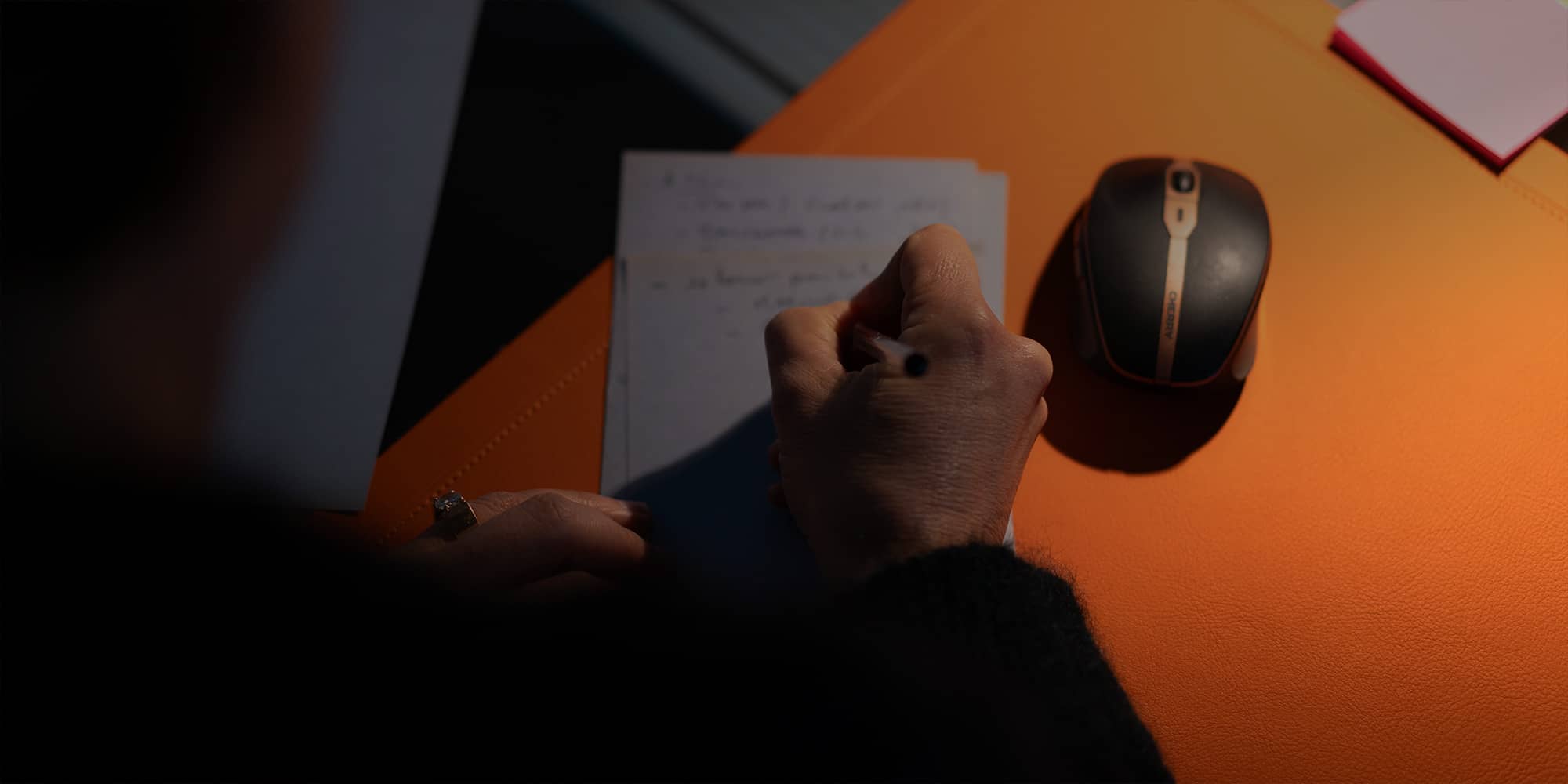 Avocate en train de signer un courrier pour illustrer la notion de cabinet et de contact