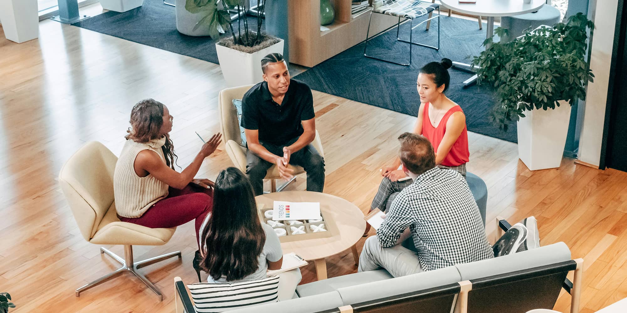 Réunion de plusieurs professionnels échangeant autour d’une table, symbolisant la coopération et la mutualisation propres au groupement d’intérêt économique (GIE)