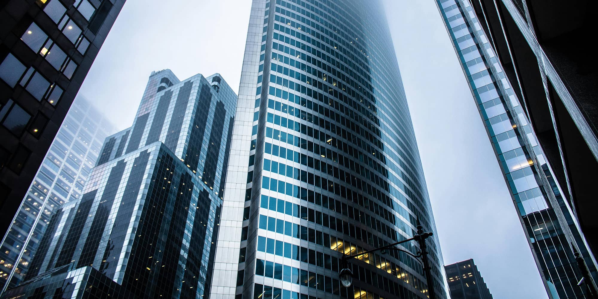 Façades de tours de bureaux modernes en verre, symbolisant la structuration et le développement d’un groupe de sociétés