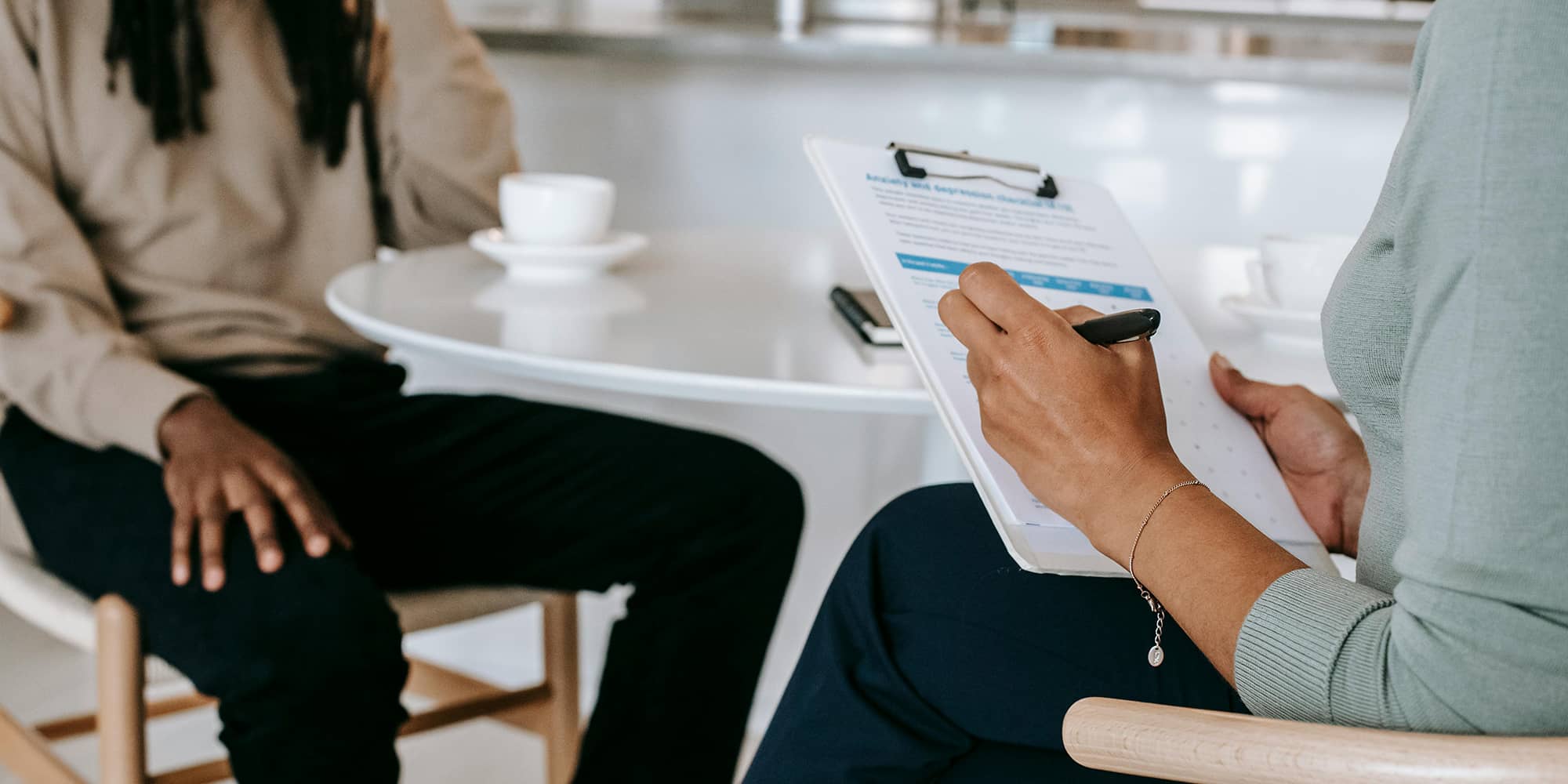 Personne tenant un clipboard et prenant des notes lors d’un échange professionnel, illustrant une démarche de recouvrement amiable de créance