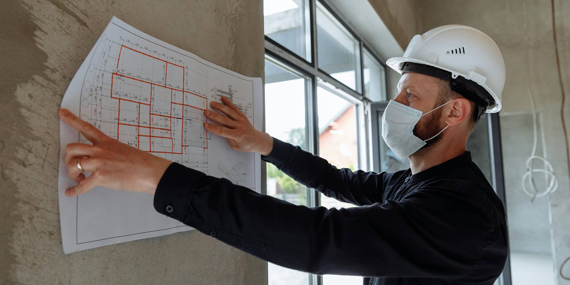 Professionnel du bâtiment analysant un plan de construction : responsabilité des constructeurs et garanties légales