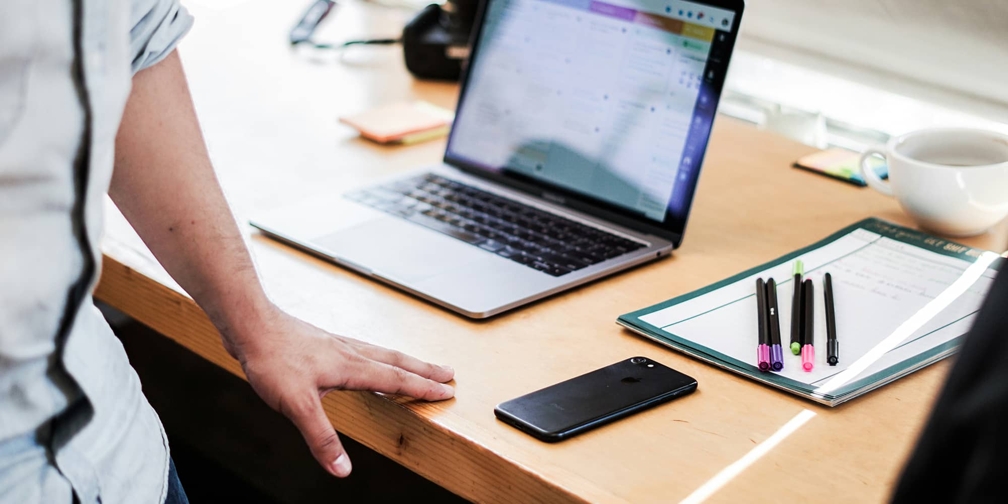Associé debout devant un bureau avec ordinateur et documents, illustrant la responsabilité personnelle de l’associé