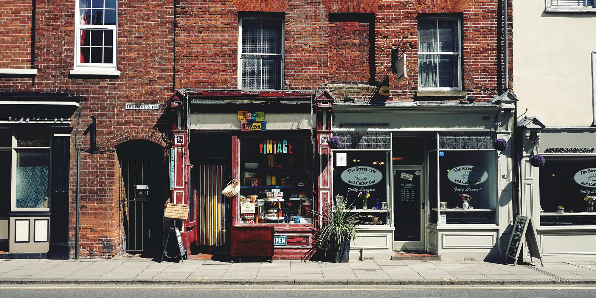 Façades de commerces en rez-de-chaussée illustrant un local commercial et l’activité de boutiques dans une rue urbaine