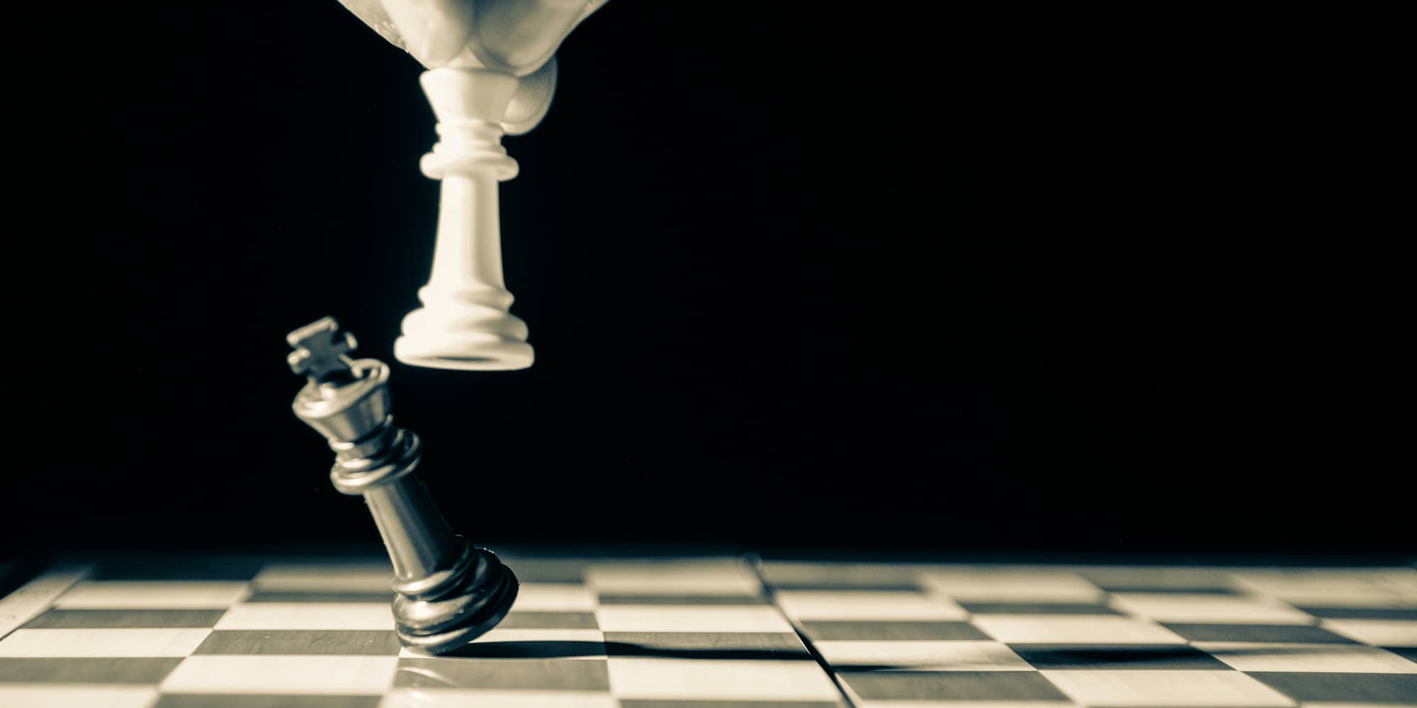 Pièce d’échecs renversée sur un échiquier symbolisant la fin brutale d’une relation entre partenaires commerciaux